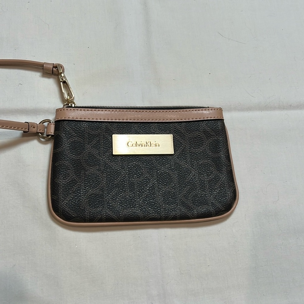 Calvin Klein monogrammed wristlet in brown with gold accents.